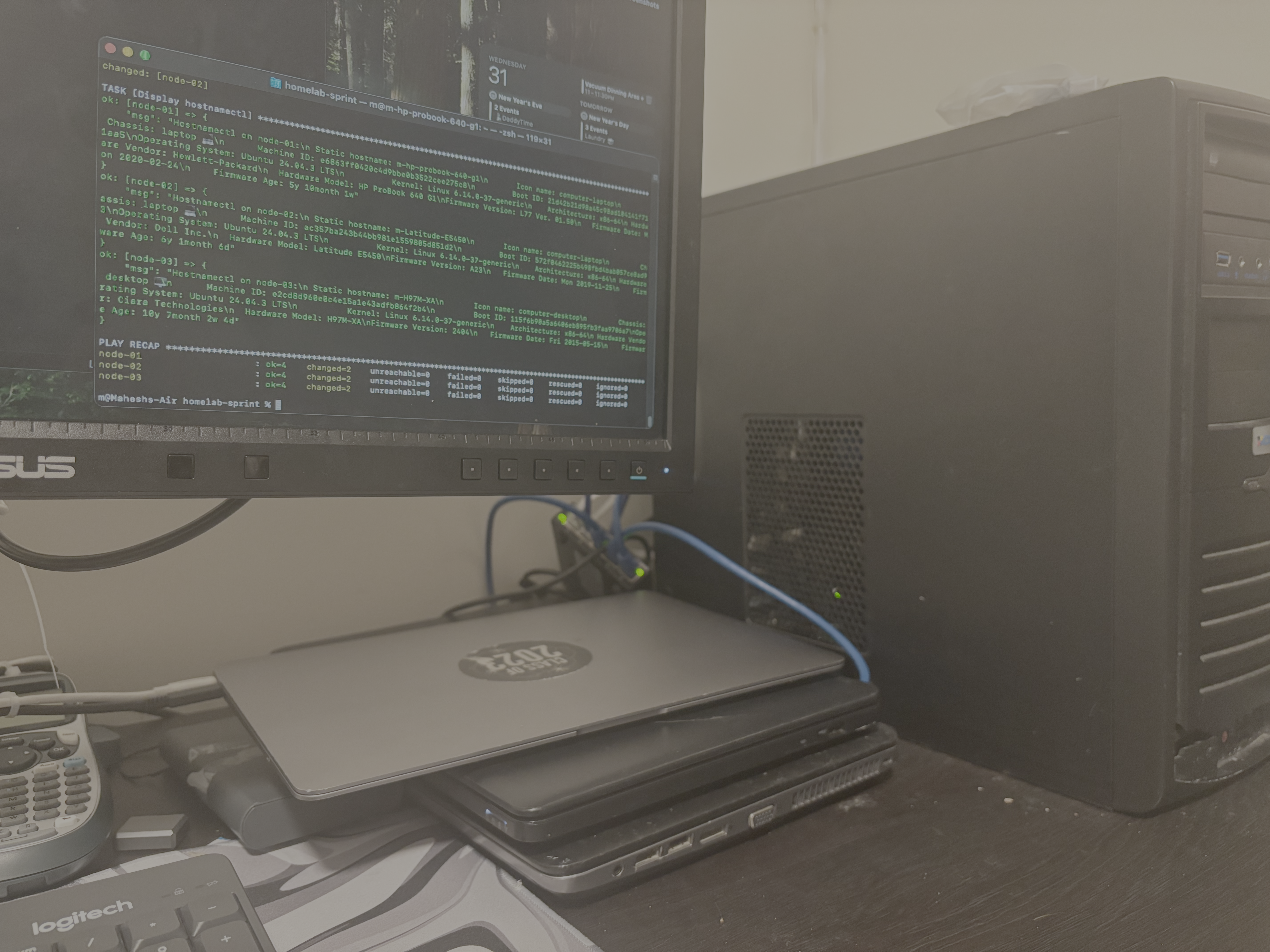 A physical view of the homelab Battle-Station. A stack of three laptops—an HP ProBook and a Dell Latitude — sits next to a black desktop PC tower (the H97M-XA). A monitor above the stack displays an Ansible terminal output, confirming that all three nodes are online and Ready.